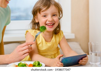 A Happy Child Eats Broccoli Only With Cartoons. Organic Cabbage And Food On A Plate. The Problem Of Feeding The Children Preschool Age