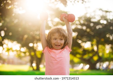 Happy child exercising outdoor. Boy workout with dumbbell in park. Sporty activity. Kid sport. Active lifestyle. - Powered by Shutterstock