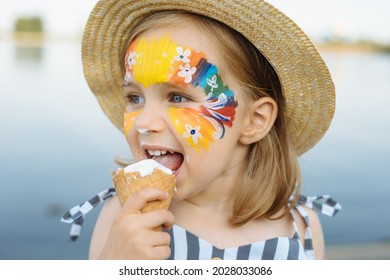 Happy child with face art paint eating ice-cream at summertime - Powered by Shutterstock