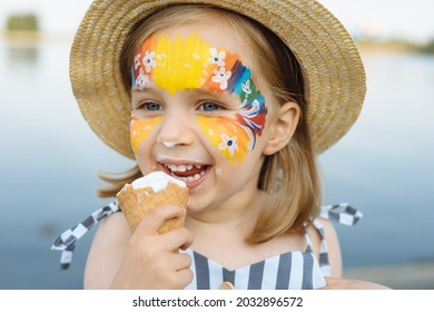 Happy child with face art paint eating ice-cream at summertime - Powered by Shutterstock