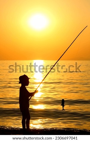 happy child fishing by the sea silhouette