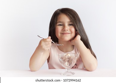 Happy Child Girl Eating Ice Cream  In White And Chocolate Bowl On White Background