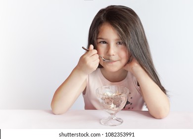 Happy Child Girl Eating Ice Cream In White And Chocolate Bowl On White Background. Enjoying Delicious.