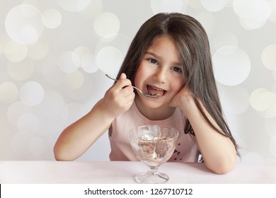 Happy Child Girl Eating Ice Cream In White And Chocolate Bowl On Light Background. Enjoying Delicious. Delicious Food.