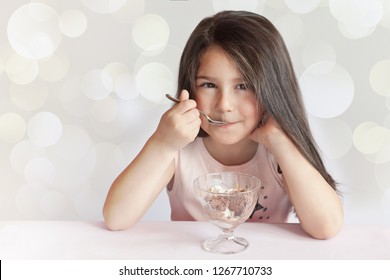 Happy Child Girl Eating Ice Cream In White And Chocolate Bowl On Light Background. Enjoying Delicious. Delicious Food.