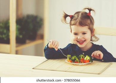 The Happy Child Girl  Eating Vegetables And Laughs