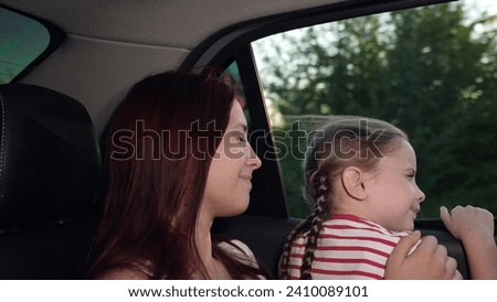 happy child girl mom looking out car window, happy faces mother child daughter, kid parent back seat car, family trip by car, smile child face, mom with little kid looking out window, child kid girl.