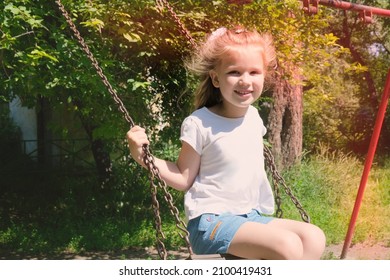 Happy child girl on swing, summer time. Life Events.  Retro toned, Soft focus effect - Powered by Shutterstock