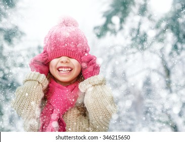 Happy child girl playing on a winter walk in nature