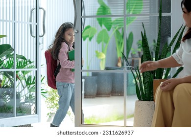Happy child girl preparing for school, and saying bye to mom and walk out the door, Little girl with mother - Shutterstock ID 2311626937