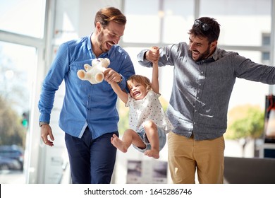 Fröhliches Kindermädchen beim Einkaufen mit schwulen Eltern.Familie Spaß beim Einkaufen.