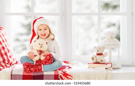 Happy Child Girl Sitting In The Winter Window Christmas