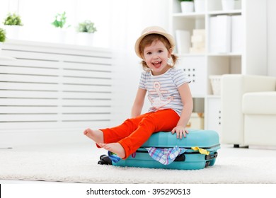  happy child girl tourist packs clothes into a suitcase for travel, vacation