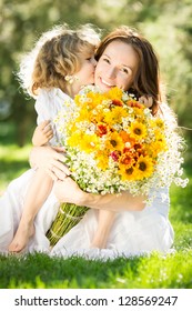 Happy Child Giving Big Bouquet Of Spring Flowers To Woman For Mother`s Day