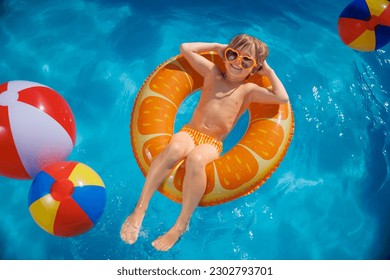 Happy child having fun on summer vacation. Top view portrait of kid in swimming pool. Active healthy lifestyle concept - Powered by Shutterstock