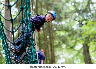 Happy Child, Healthy Teenager School Boy Enjoying Activity In A Climbing Adventure Park On A Summer Day