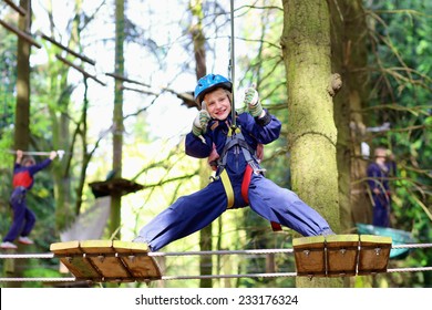 Happy Child, Healthy Teenager School Boy Enjoying Activity In A Climbing Adventure Park On A Summer Day