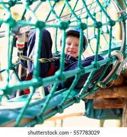 Happy Child, Healthy Teenager School Boy Enjoying Activity In A Climbing Adventure Park On A Summer Day