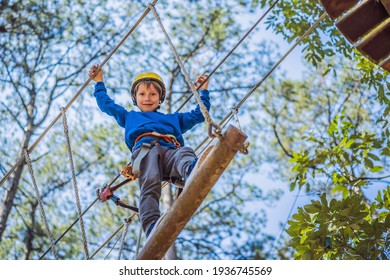 Happy Child In A Helmet, Healthy Teenager School Boy Enjoying Activity In A Climbing Adventure Park On A Summer Day