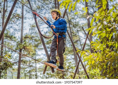 Happy Child In A Helmet, Healthy Teenager School Boy Enjoying Activity In A Climbing Adventure Park On A Summer Day