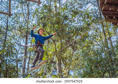 Happy Child In A Helmet, Healthy Teenager School Boy Enjoying Activity In A Climbing Adventure Park On A Summer Day