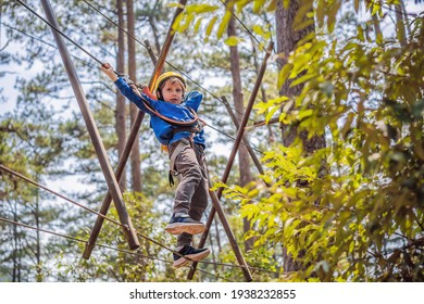 Happy Child In A Helmet, Healthy Teenager School Boy Enjoying Activity In A Climbing Adventure Park On A Summer Day