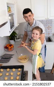 happy child help to father in kitchen. kid cooking food with dad. little girl, man in apron making dough, baking pie, cookies, making biscuit. family together home at stove, oven