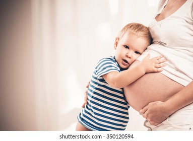 Happy Child Holding Belly Of Pregnant Woman