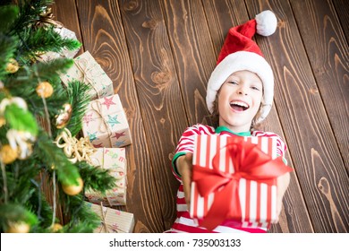 Happy Child Holding Gift Box. Funny Kid On Christmas Eve. Top View Portrait Of Child. Xmas Holiday Concept