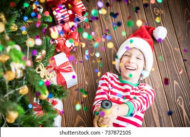 Happy Child Holding Party Popper. Funny Kid On Christmas Eve. Xmas Holiday Concept