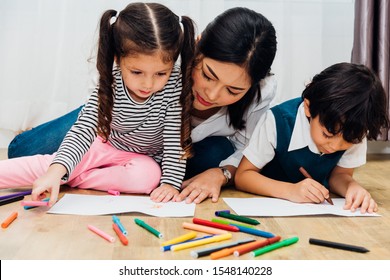 Happy Child Kid Boy And Girl Kindergarten Drawing On Peper Teacher Education With Beautiful Mother At Interior Room Home