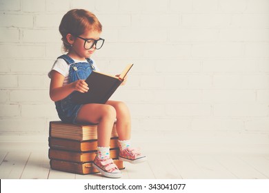 happy child little girl with glasses reading a books - Shutterstock ID 343041077
