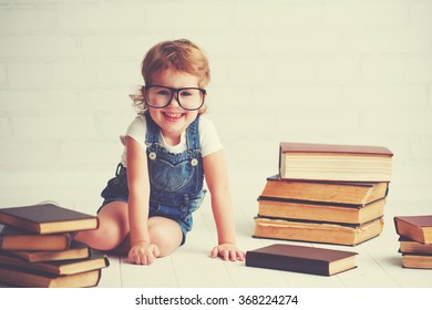 happy child little girl with glasses reading a books - Shutterstock ID 368224274