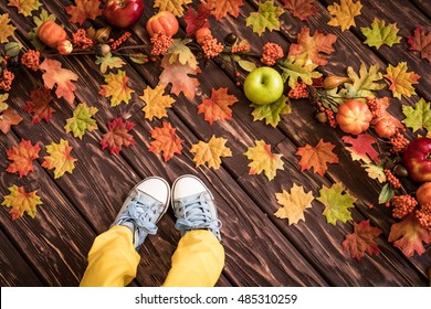 Happy child lying on autumn leaves. Top view portrait of funny kid at home. Thanksgiving holiday concept