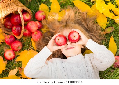 Happy child lying on fall leaves. Funny kid outdoors in autumn park - Powered by Shutterstock