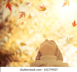 Happy child with maple leaves in autumn park against yellow blurred leaves background. Freedom concept - Powered by Shutterstock