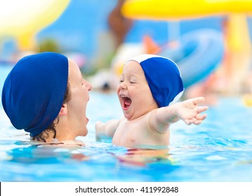 Happy Child And Mom With Swimming Pool Cap Have Fun In A Pool