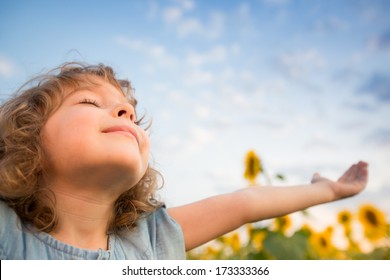 Happy Child Outdoors In Spring Sunflower Field