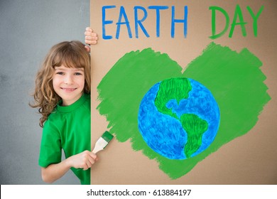 Happy Child Painting The Cardboard With Green Color. Kid Having Fun At Home. Spring Earth Day Holiday Concept