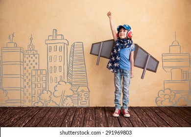 Happy child playing at home. Kid having fun with toy paper wings - Shutterstock ID 291969803
