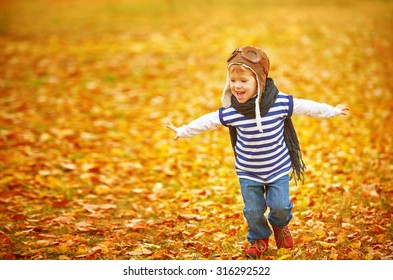 Happy Child Playing Pilot Aviator And Dreams Outdoors In Autumn