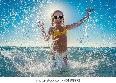 Happy child playing in the sea. Kid having fun outdoors. Summer vacation and healthy lifestyle concept - Powered by Shutterstock