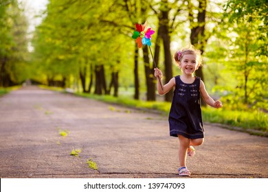 Happy Child Playing In A Spring Garden