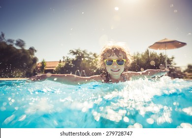 Happy Child Playing In Swimming Pool. Summer Vacation Concept