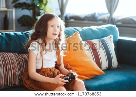 Similar – happy child playing video games with gamepad at home