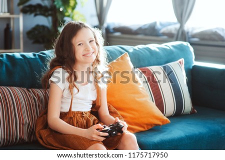 Similar – happy child playing video games with gamepad at home