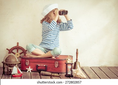 Happy Child Playing With Vintage Nautical Things. Kid Having Fun At Home. Summer Sea Dream And Imagination. Adventure And Travel Concept. Retro Toned Image