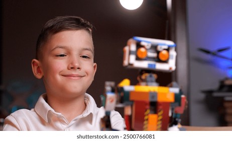 Happy child programming robot from building blocks at home