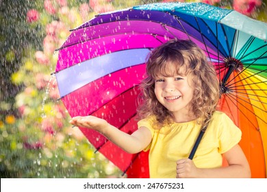 Happy Child In The Rain. Funny Kid Playing Outdoors In Spring Park