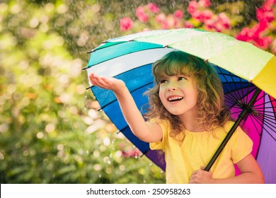 Happy Child In The Rain. Funny Kid Playing Outdoors In Spring Park